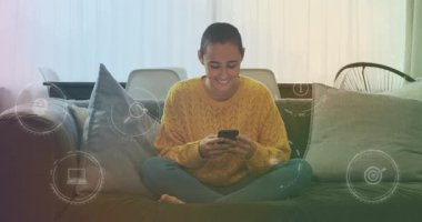 Yüzen bar çizelgesinde telefon kullanan bir kadın, teknoloji demosunda kanepenin üzerinde süzülen cam ikonlar. Teknoloji, yaşam tarzı, modern, gündelik, yenilik, dijital, iletişim