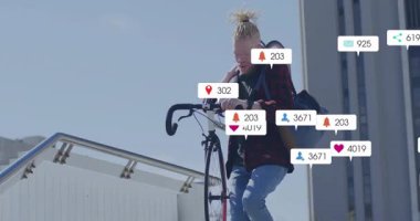 Bisikletle şehir rampasına tırmanan ve pazarlama verilerini gösteren yüzen sosyal medya ikonları olan bir adam. Kentsel, aktif, enerjik, yaşam tarzı, modern, canlı, bağlantı