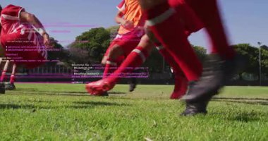 Futbolcular çim sahası üzerinde koşuyor spor teknolojisi kavrayışları için AR kodlarını sergiliyorlar. Atletizm, takım çalışması, yenilik, spor giyim, açık hava, yüksek enerji, rekabet