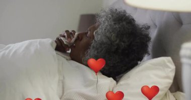 Evde kitap okuyan yaşlı bir kadın, sağlık eğitimini yüzen kalp ikonlarıyla örtüyor. Sevgi, rahatlama, samimiyet, rahatlık, sıcaklık, nostalji.