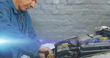 Otomobil atölyesindeki motor kompartımanında kıdemli tamirci, animasyon kablo diyagramlarını gösteriyor. Otomotiv, endüstriyel, onarım, mühendislik, mekanik, araç, bakım