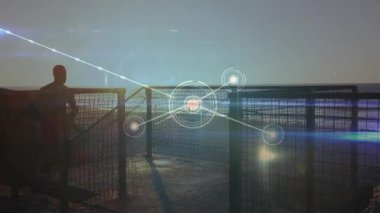 Adam gün batımında iskele korkuluklarına yaslanıyor, dijital ağ hatlarını ve teknoloji için düğümleri gösteriyor. Siluet, rıhtım, bağlantı, teknoloji, navigasyon, boş zaman, modern