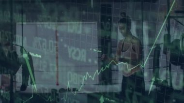 Kadın kaldırıcı spor salonunda halterin altına çömelme hazırlıyor, erkek koç üst üste binen finans tablolarını izliyor. Kuvvet, motivasyon, analitik, fitness, takım çalışması, sağlık, yenilik