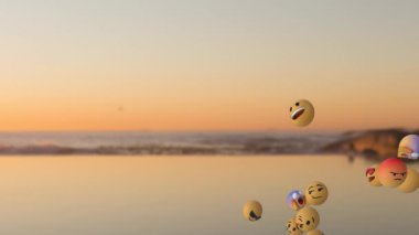 Gün batımında gerçeküstü dijital görüntülerle sakin okyanusun üzerinde dans eden yüzen üç boyutlu emoji küreleri kümesi. Sürrealizm, animasyon, dijital alarm, fantezi, canlı, anlamlı, suda