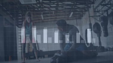 Erkek antrenörle tezgaha yaslanan kadın sporcu şınav çekiyor. Formda kalma verileri havada süzülüyor. Spor, güç, kararlılık, yoldaşlık, eğitim, modern, endüstriyel