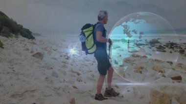 Sırt çantaları ve yürüyüş direkleriyle sahil yürüyüşü yapan bir adam, teknolojik veri akışlarıyla hologram küreyi gösteriyor. Macera, keşif, vahşi doğa, açık hava, teknoloji, navigasyon, dayanıklılık.