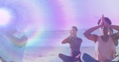 Kumlu sahilde yoga yapan üç kadın güneş ışığı ve mor ışınlarla sağlık teması sergiliyorlar. Sağlık, huzur, farkındalık, maneviyat, sükunet, ahenk, rahatlama.