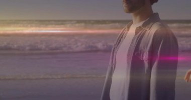 Çiftler plajda gün batımını paylaşıyor. Kalp ikonunu gösteren bir sağlık uygulaması. Romantizm, arkadaşlık, sükunet, yansıma, manzara, sükunet, şefkat