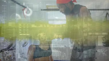 Kadın boksör havluyla örtülmüş köşede dinleniyor, erkek antrenör spor salonunda spor salonu verileriyle antrenörlük yapıyor. Sporcu, antrenörlük, dijital, performans, güç, eğitim, motivasyon