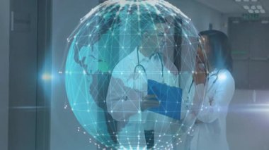 Doktorlar hastane koridorunda notları tartışıyorlar, dijital küresel ağ hologramının yer aldığı. Tıp uzmanları, takım çalışması, sağlık teknolojisi, fütüristik, klinik çevre, işbirliği, yenilik