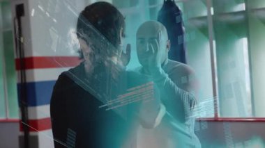 Spor salonundaki antrenman partnerleri kum torbasını ve holografik kaplamayı göstererek antrenmanları engelliyor. Sporcular, fitness, teknoloji, yenilik, güç, takım çalışması, modern