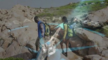 Sahilde araştırma yapan iki yürüyüşçü pusula grafiğiyle kayalık arazide geziniyor. Macera, keşif, navigasyon, açık hava, engebeli, manzaralı, aktif