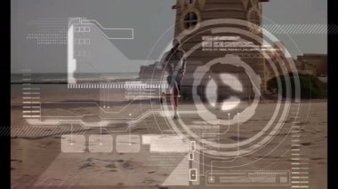 Erkek koşucu kumsalda koşuyor, fitness teknolojisi HUD grafikleri ve performans verilerini gösteriyor. Atletik, motivasyon, açık hava, modern, kıyı, yaşam tarzı, aktif giyim