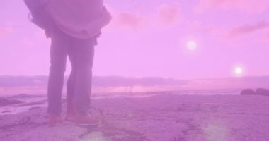 Gün batımında kayalık kıyı şeridi boyunca yürüyen çift, yüzen finans grafik animasyonlarıyla. Romantik, maceracı, huzur, doğal, dinamik, manzaralı, ahenkli