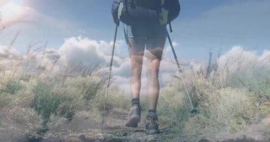 İki yürüyüşçü çimenli patika boyunca yürüyor, animasyon fitness istatistikleri, harita örtüsü, sırt çantası ikonu gösteriyor. Macera, keşif, açık hava, doğa, aktivite, yolculuk, sağlık