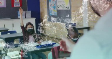 Kız, sınıfın resepsiyonunda el kaldırıyor. Yazı yazıyor. Maske takıyor. Öğrenim, eğitim, okul, sınıf, okur yazarlık, öğrenci, öğretim