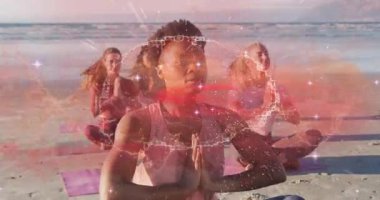 Dört kadın paspaslarda plaj yogası yapıyor, yüzen enerji örtüsü ve sağlık veri tabloları sergiliyor. Meditasyon, farkındalık, dinginlik, refah, uyum, doğa, maneviyat
