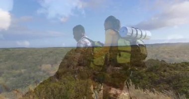 Otlak araziye bakan çimenli tepede yürüyüş yapan iki yürüyüşçü, animasyon seyahat rotası haritası sergiliyorlar. Macera, keşif, vahşi doğa, açık hava, yolculuk, doğa, manzara