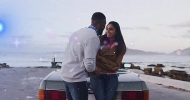 Adam, kadının önünde diz çöküyor. Üstü açılır arabanın yanındaki kayalık plajda düğün reklamları için yüzük kutusu gösteriyor. Romantizm, evlilik teklifi, macera, mahsul, manzara, kutlama, zarafet