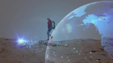 Teknoloji gösteriminde kayalık tepede dengede duran kadın yürüyüşçü, yüzen dijital küre örtüsü içeriyor. Macera, keşif, dayanıklılık, açık hava, engebeli, hareketlilik, yenilik