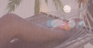 Pazarlamacı, animasyon çizelgesi ve palmiye başı simgeleri olan hamak görüntüleri kullanarak sağlık reklamı tasarlıyor. Dinlenme, sükunet, tropikal, boş zaman, yaz, açık hava, sağlık