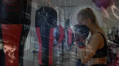 Ağır torba yumruklayan, boks eldiveni takan, yüzen veri şebekesiyle spor yapan bir bayan sporcu. Fitness, güçlendirme, kararlılık, atletizm, güç, motivasyon, egzersiz