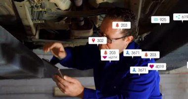 Erkek tamirci, otoparkta aracın altında yüzen sosyal medya simgeleri sergiliyor. Teknisyen, tanı, endüstriyel, dijital, teknoloji, bakım, fütüristik