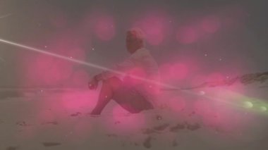 Sunrise 'da kumlu sahilde diz çöküp sağlık temasını canlandıran kıdemli bir adam. Sakin, düşünceli, doğal, ruhani, sakin, manzaralı, yansıtıcı.