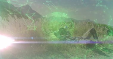 Açık hava fotoğrafçısı çayırda uzanıyor. Dijital teknoloji şebekesiyle gökyüzünü tarıyor. Doğa, keşif, yenilik, sükunet, teknoloji, macera, kırsal