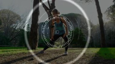 Ormanlık alanda geniş açılı hamleler yapan bir kadın dairesel dijital HUD uygunluk örtüsünü gösteriyor. Açık hava, fitness, teknoloji, sağlık, aktif giyim, görselleştirme, doğa