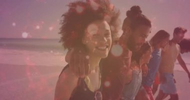 Arkadaşlar gün batımında kumsalda kol kola yürüyorlar, sağlık verileri grafiği ve kalp ikonu havada uçuşuyor. Kumsal, dostluk, günbatımı, eğlence, doğa, mutluluk, bağ