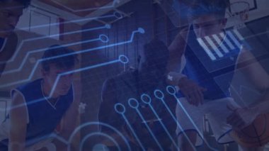 Koç tablet tutarken oyuncular öne eğilip basketbol oynarken teknik devrelerin attığını tartışıyor. Atletik, takım çalışması, yenilik, strateji, performans, fütüristik, eğitim