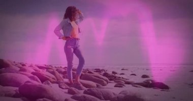 Kayalık sahilde, yüzen teknoloji grafikleri ve simgeleriyle gözlerini gölgeleyen bir kadın. Sahil, macera, eğlence, doğal, sükunet, keşif, manzara