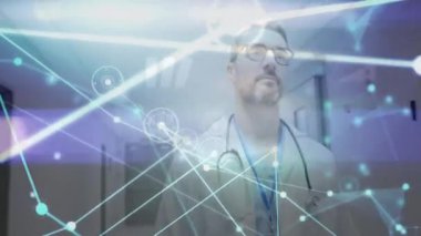 Erkek doktor hastane koridorunda yürüyor, sağlık teknisyenleri için ışık kaplamalı animasyon çizelgeleri gösteriyor. Tıbbi, sağlık, teknoloji, profesyonellik, yenilik, klinik, geleceksel