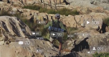 Erkek yürüyüşçü kanyonda geziniyor, görüntüyü takip eden mesajları gösteren yüzen sosyal medya simgeleri. Macera, keşif, açık hava, vahşi doğa, engebeli, modern, teknoloji