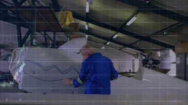 Havacılık hangarındaki uçak gövdesini inceleyen teknisyen finansal hat haritalarını örtüyor. Sanayi, mühendislik, işçilik, teknik, hassasiyet, güvenlik, imalat