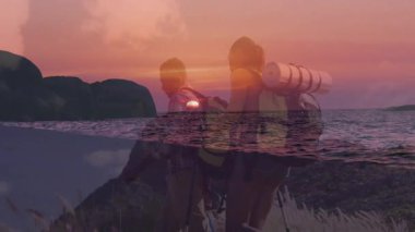 Gün batımında kıyı şeridinde yürüyen yürüyüşçüler seyahat temalı okyanus ufuklarını harmanlıyorlar. Macera, keşif, manzara, romantizm, vahşi doğa, dinginlik, açık hava