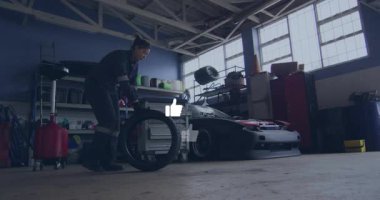 Otomotiv garajında araba lastiğini kaldıran kadın tamirci. Animasyon gösterge simgeleri basınç gösteriyor. Tamirci, atölye, endüstriyel, otomotiv, araçlar, hassasiyet, bakım