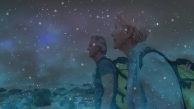 Günbatımında kayalık sahilde yürüyüş yapan çift kar tanesi animasyonları ve teknoloji için yıldız patlamaları sunuyor. Macera, keşif, vahşi doğa, manzara, sükunet, doğa, açık hava