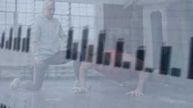 Jimnastik salonunda baro çizelgesi ve EKG kaplamalı şınav çeken erkek gözlemcisi kadın fitness eğitmeni. Eğitim, sağlık, güç, motivasyon, analitik, teknoloji, sağlık