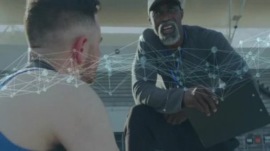 Stadyumdaki panoya bakan erkek koç eğitim verilerini gösteren animasyon ağ örtüsüyle. Sporcu, akıl hocası, dijital, iletişim, motivasyon, açık hava, işbirliği