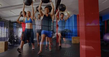 Spor salonunun içinde yüzen veri grafiklerini gösteren tıbbi toplar tutan bir grup. Kuvvet, takım çalışması, kardiyo, eğitim, motivasyon, dayanıklılık, çağdaş