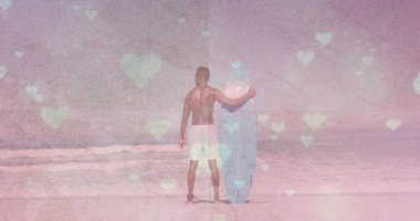 Kumlu plajda mavi sörf tahtası tutan sörfçü, sağlık pazarlaması için pastel kalplerle örtüşüyor. Okyanus, sahil, rahatlık, sükunet, canlılık, yaşam tarzı, dinginlik