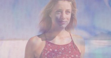 Güneşli sahilde duran bir kadın, yüzen pastel şekilli teknoloji grafikleri sergiliyor. Sahil, gün batımı, pastel, dinginlik, moda, sağlık, rahatlık