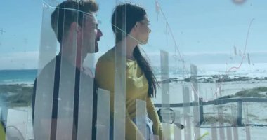 Sahilde sarı arabanın yanında duran çift, yüzen finansal tabloları ve çizgi grafiklerini izliyorlar. Romantik, macera, sahil, boş zaman, iyimserlik, modern, manzaralı