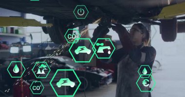 Otomotiv atölyesinde açı öğütücü kullanan tamirci, yeşil simgeleri karbondioksit ölçümlerini gösteriyor. Sanayi, zanaat, yenilik, teknoloji, sürdürülebilirlik, bakım, ekipman