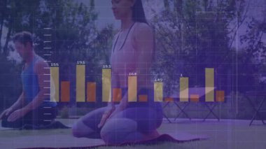 Yoga partnerleri parkta poz çalışıyor, dijital bar grafikleri izleme fitness ölçümlerinin üzerinde yüzüyor. Sağlık, zindelik, açık hava, sağlık, uyum, aktivite, teknoloji