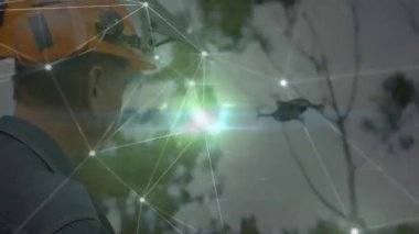 Forest Tech 'te kuadcopter drone' u izleyen, parlayan ağ arayüzü olan bir adam. Teknoloji, yenilik, vahşi doğa, bağlantı, keşif, güvenlik, açık hava