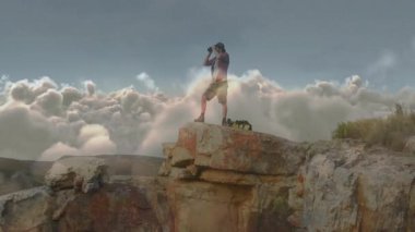 İnsanoğlu, seyahat endüstrisindeki kayalık uçurumlardaki dürbünlerle bulutları tarıyor. Animasyon haritası eşliğinde. Macera, keşif, açık hava, doğa, manzara, engebeli, keşif