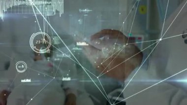 Üst düzey erkek doktor, hastanede akıllı telefonla iletişim kuruyor, yüzen düğüm çizelgeleri sergiliyor. Tıp uzmanları, teletıp, fütüristik, dijital sağlık, işbirliği, sağlık teknolojisi, yenilik